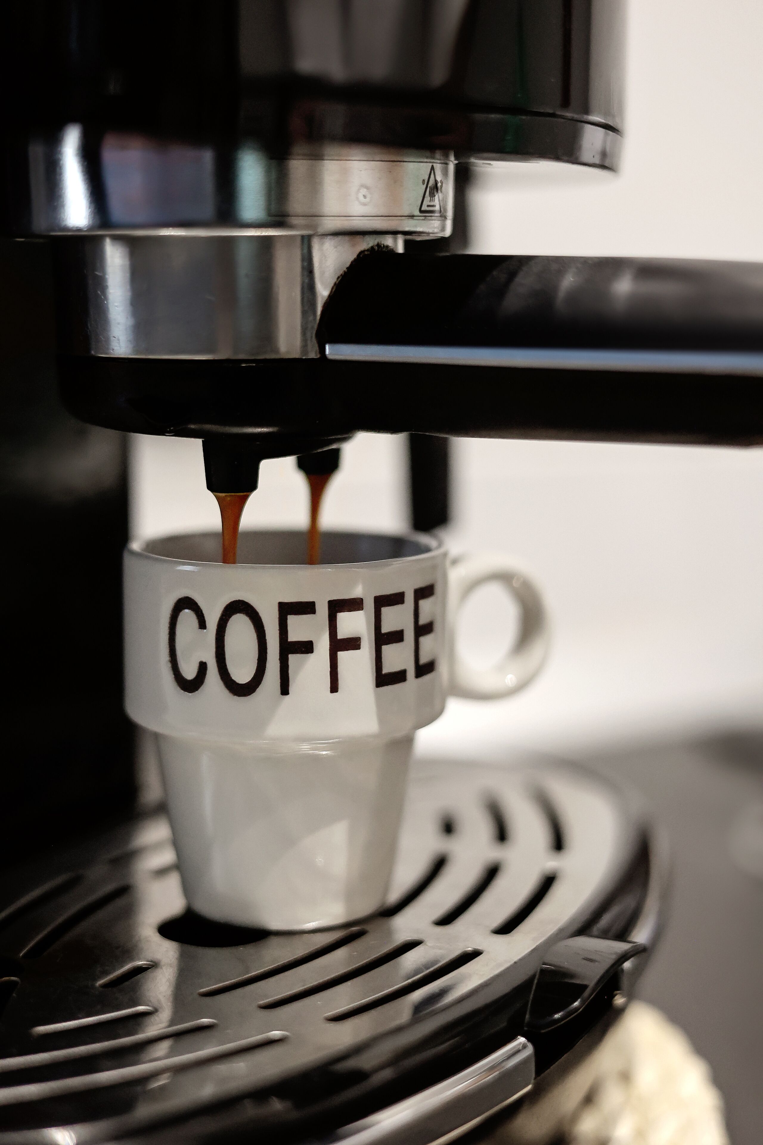A coffee machine dispensing coffee into a mug labeled "COFFEE".