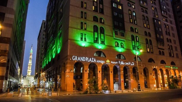 Un hôtel doté de fenêtres en arc de cercle et d’une enseigne bien visible indiquant « Grand Plaza ».