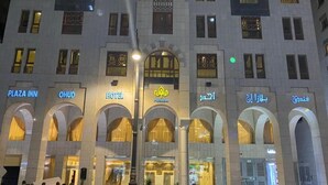 A hotel facade with multiple arches and signage for Plaza Inn, OHUD, and Hotel Plaza Inn. - Plaza Inn Ohud (Madinah)