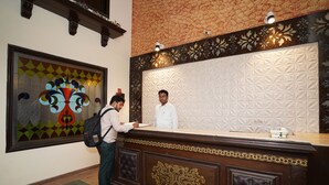 A reception desk with a decorative panel and a framed artwork above it. - Lyf Corporate Suites. New Friends Colony (New Delhi)