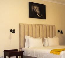Un dormitorio con una cama grande, dos mesitas de noche y una lámpara de pared.
