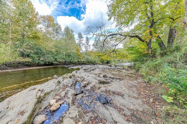 A natural landscape with a river, rocky terrain, and dense trees. - River's Song Condo- Convenient for Walking (Helen)