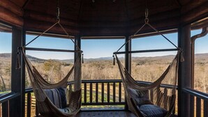 A wooden deck with two wicker hammocks facing a scenic view of hills and trees. - Five Star Lodge and Stables is pet friendly with a big mountain view. hot tub, firepits. Ideal for Weddings and Corporate Retreats (Morganton)