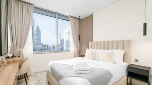 Une chambre d’hôtel avec un grand lit, un bureau et une vue sur les toits de la ville.
