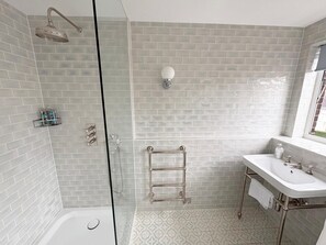 A modern bathroom with a glass-enclosed shower, a white sink with a mirror, and a towel rack. - The Elden - No.10 (London)