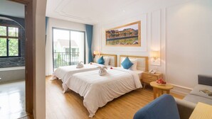A hotel room with two beds, a balcony, a painting, and a small table with a lamp. - Lime Villa - Twin
Rilassati e ricaricati in quest'oasi di quiete ed eleganza. (Hội An)