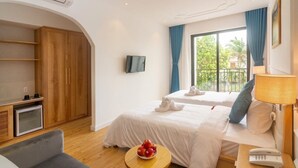 A hotel room with two beds, a TV, a small table with fruit, a desk with a lamp, and a wardrobe. - Lime Villa - Twin
Rilassati e ricaricati in quest'oasi di quiete ed eleganza. (Hội An)