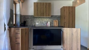 A modern kitchen with wooden cabinets, a built-in oven, and a sink. - Neurenovierte 60m2 Fewo Xaverl zw. Stadt&bergen (Holzkirchen)