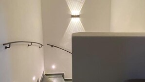 A modern staircase with a wall-mounted picture and a spotlight. - Neurenovierte 60m2 Fewo Xaverl zw. Stadt&bergen (Holzkirchen)