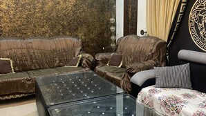 Una sala de estar moderna con una pared estampada, una mesa de centro de vidrio y un sofá con cojines con diseños.