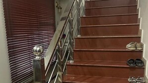 Una escalera con barandilla de metal y escalones de madera.