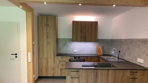 Una cocina moderna con armarios de madera, horno empotrado y una isla grande con fregadero.