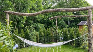 Una hamaca colgada entre árboles en un jardín exuberante.