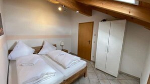 A bedroom with a wooden bed, a wardrobe, and a door.