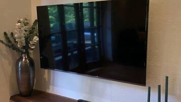 Ein Flachbildfernseher an der Wand über einem Holzregal.