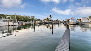 A marina with docked boats, calm water, and a wooden dock. - Spectacular Sunset, Ocean Views, Top fl, Key Largo Condo (Key Largo)