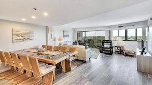 A spacious living area with a dining table, sofas, and a balcony with a view. - Spectacular Sunset, Ocean Views, Top fl, Key Largo Condo (Key Largo)