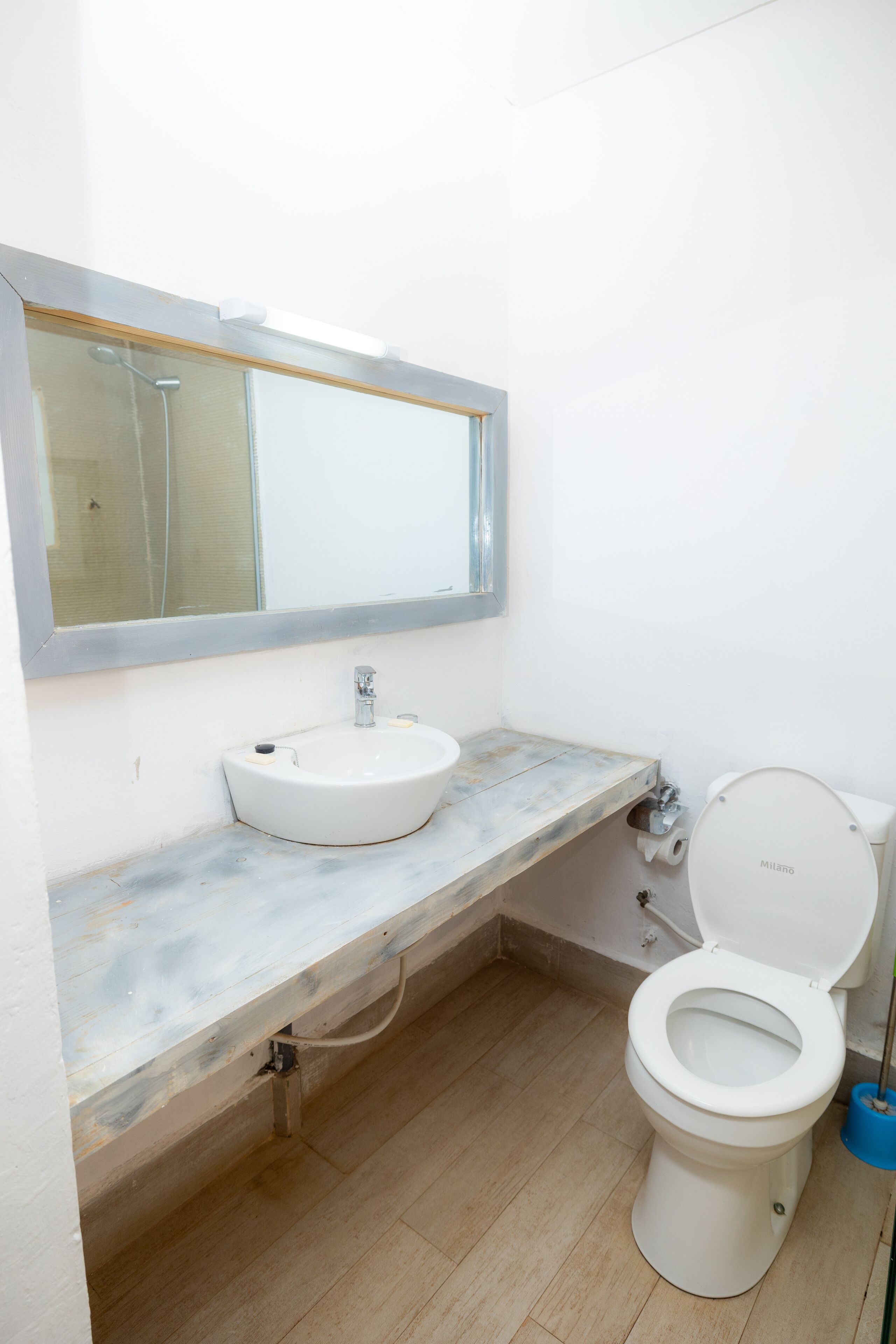 A bathroom with a white sink, a mirror, and a toilet.