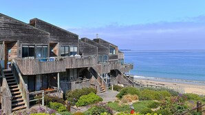 A multi-story wooden building with balconies overlooking a beach. - 3914 Pacific Sandpiper ~ Oceanfront Condo, Pool/Spa (Monterey)