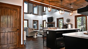 A spacious living area with a fireplace, a television, and a dining area with a large island.
