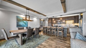 A modern kitchen with dark wood cabinets, stainless steel appliances, and a central island.