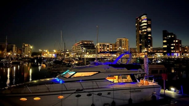 A marina at night with a large yacht docked, surrounded by city buildings and illuminated by artificial lights. - Superyacht on 5* Town Quay Marina, Southampton (Southampton)