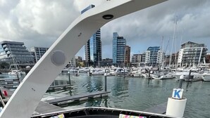 A boat deck with a curved white structure, a seating area with cushions, and a round table. - Superyacht on 5* Town Quay Marina, Southampton (Southampton)