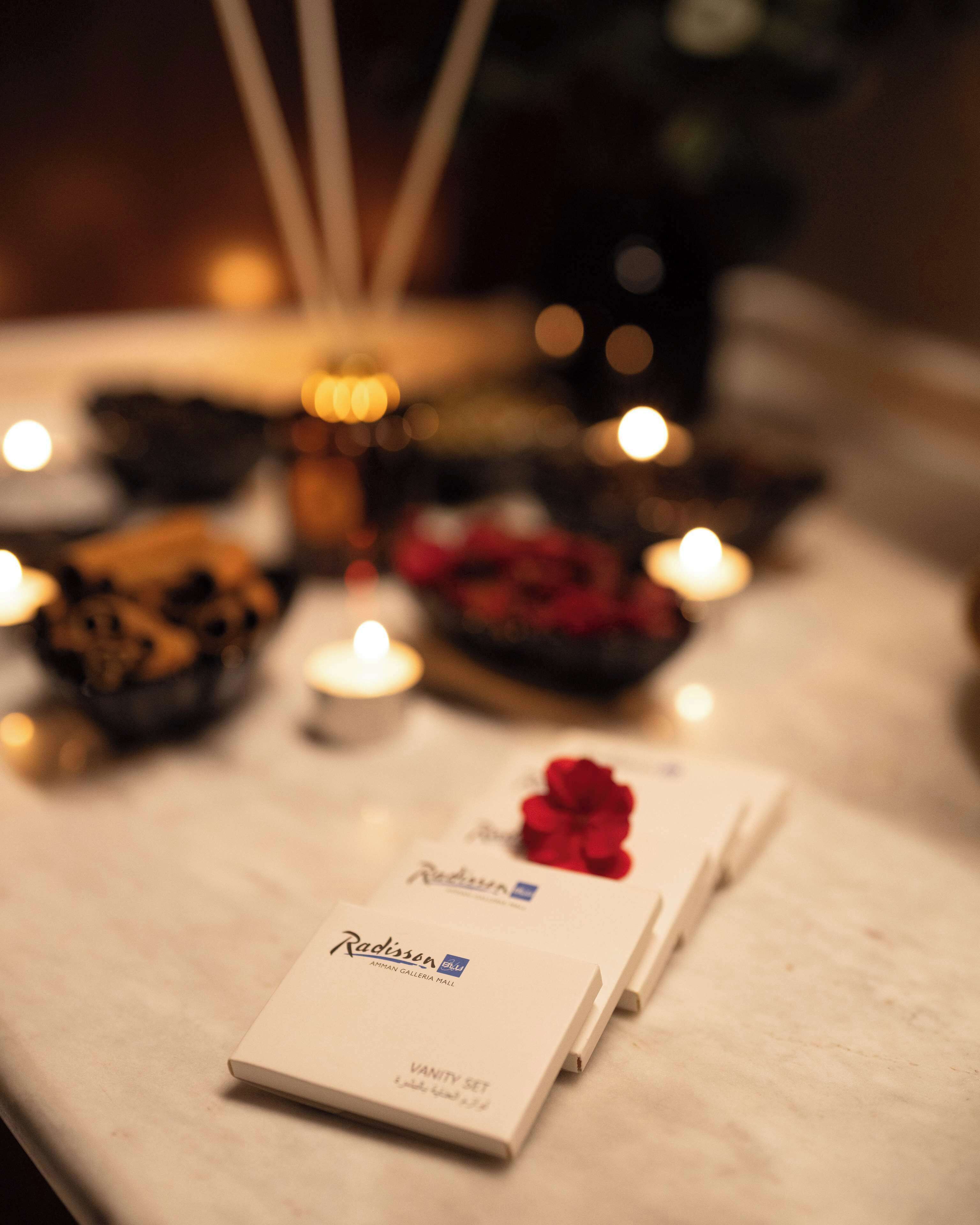 Een tafel met een Radisson Blu toilettas en kaarsen.