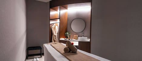 A modern bathroom with a bench, a towel, and a mirror.
