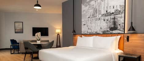 Una habitación de hotel moderna con una cama grande, un escritorio y una silla.