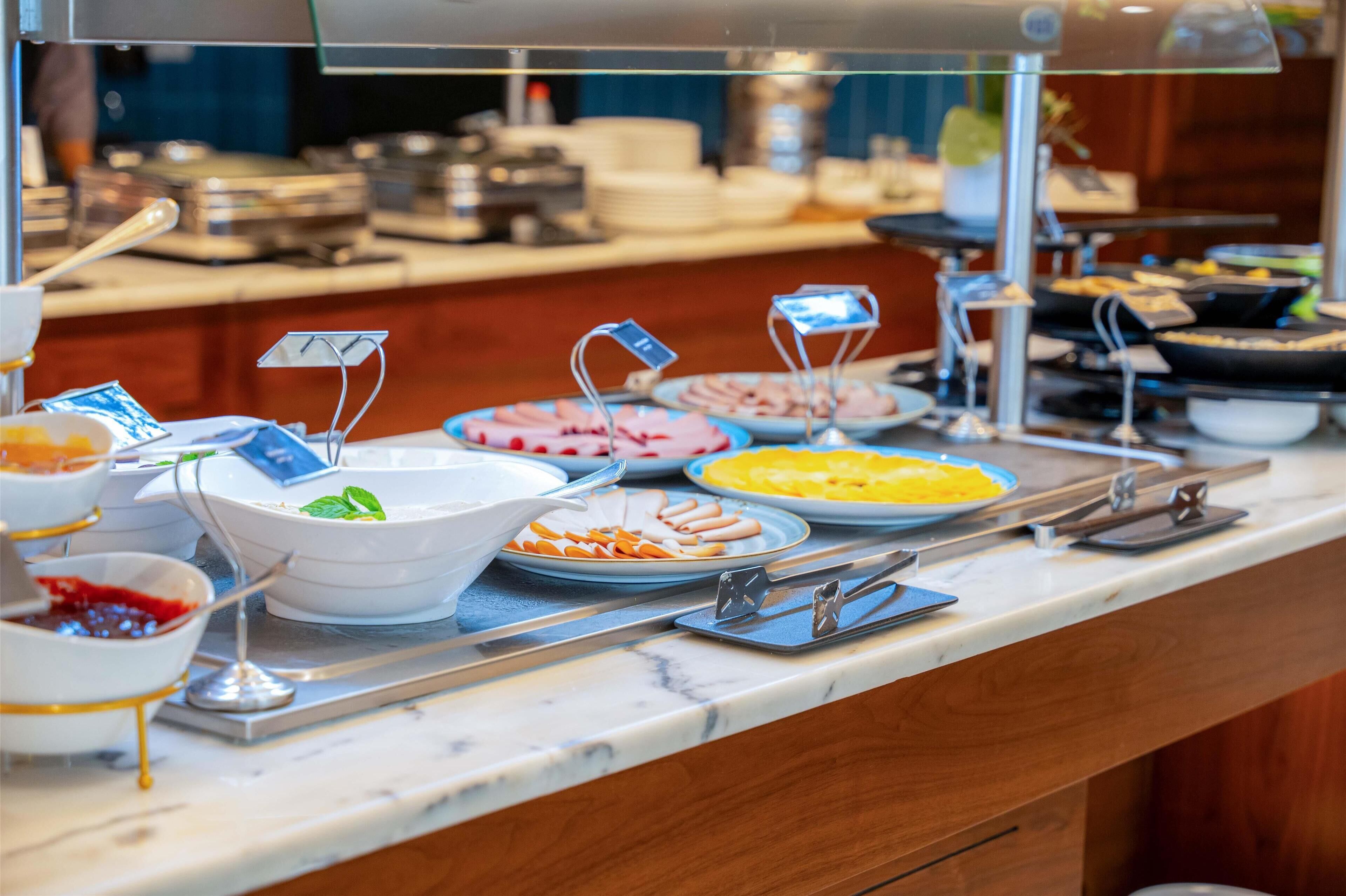 A buffet with various food items and utensils.
