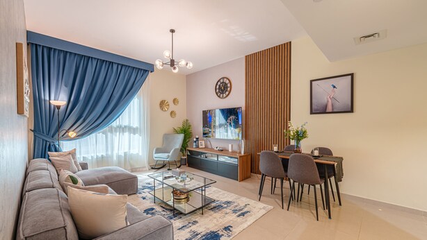 En moderne stue med sofa, sofabord og spiseplads.