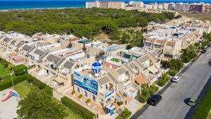 A residential area with houses, a street, and a view of the sea.