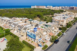 Un barrio residencial con casas, una calle y vistas al mar.