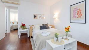 A hotel room with a bed, bedside table, lamp, and artwork.