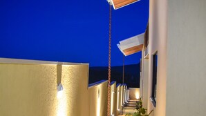 Un pasillo con paredes iluminadas y techo de madera que conduce a la entrada de un edificio.
