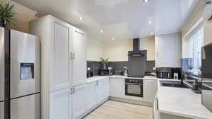 A modern kitchen with white cabinets, stainless steel appliances, and a central island.