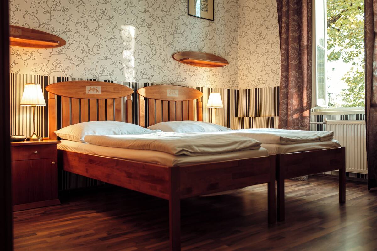 Un lit double avec une tête de lit en bois et deux lampes de chevet.