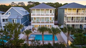 A beachfront property with a pool, multiple balconies, and a two-story structure. - Seagrove - 1 Block from Beach, Golf Cart, Private HEATED Pool, Game Room, Bikes & Tesla Charger! (Santa Rosa Beach)