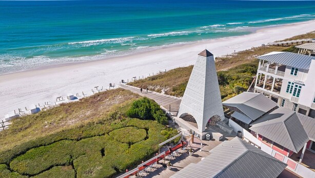 A beachfront property with a prominent white pyramid structure, a beach with white sand, and a clear blue ocean. - Seagrove - 1 Block from Beach, Golf Cart, Private HEATED Pool, Game Room, Bikes & Tesla Charger! (Santa Rosa Beach)