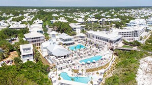 A resort with multiple buildings, a central pool area, and a beach.
