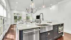 A spacious kitchen with a large island, stainless steel appliances, and pendant lighting.