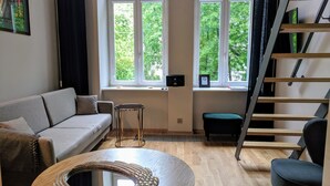 Un salon moderne avec un canapé, une table ronde et un escalier.