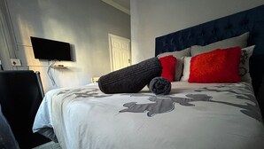 A hotel room with a bed, a flat-screen TV mounted on the wall, and a door. - 57onWYNNE (Cape Town)