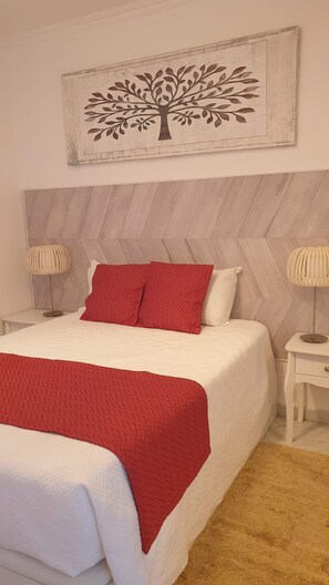 Relax in a serene bedroom with a large bed, nightstands, and a beautiful artwork above.