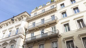 A multi-story building with balconies, large windows, and decorative moldings.