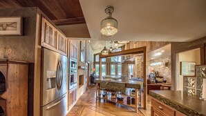 Una cocina amplia con armarios de madera, un refrigerador de acero inoxidable y una isla grande con pileta.