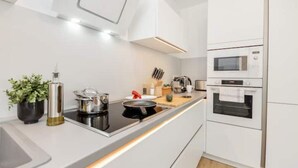 Une cuisine moderne équipée d’une cuisinière, d’un four à micro-ondes et d’un four traditionnel.