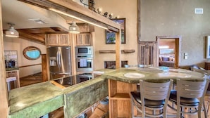 A kitchen with wooden cabinets, stainless steel appliances, and a round dining table with chairs.