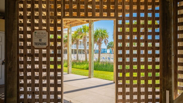 A wooden gate with a sign indicating no trespassing. - Whispering Waves: Ocean View Condo With Covered Balcony (Oak Island)